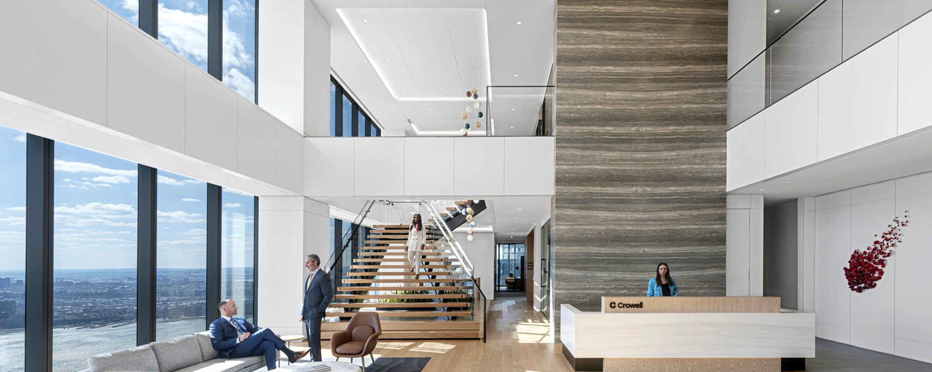 Main reception area with seating next to floor to ceiling windows and staircase Main reception area with seating next to floor to ceiling windows and staircase