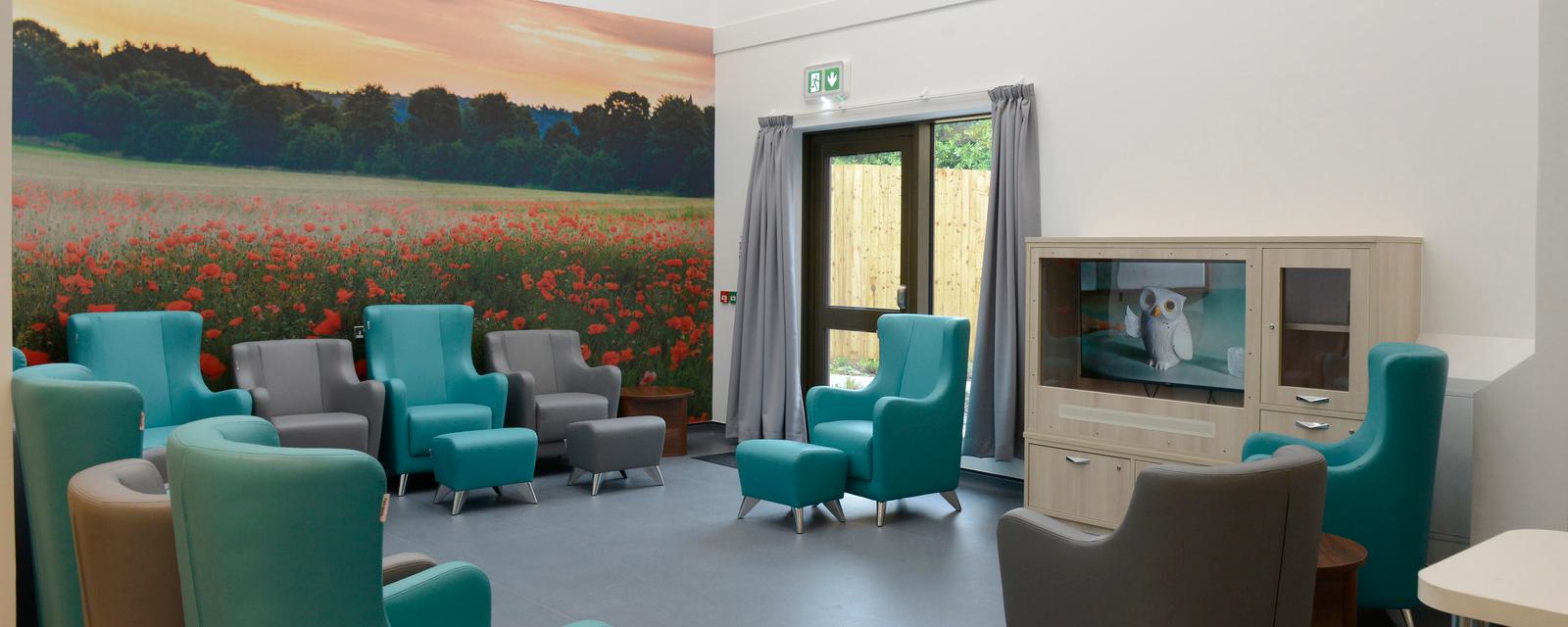 Ruby Ward - new lounge area with large photograph on wall with field full of poppies