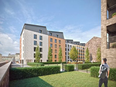 Exterior of buildings with person wearing a rucksack standing on a lawn Exterior of buildings with person wearing a rucksack standing on a lawn