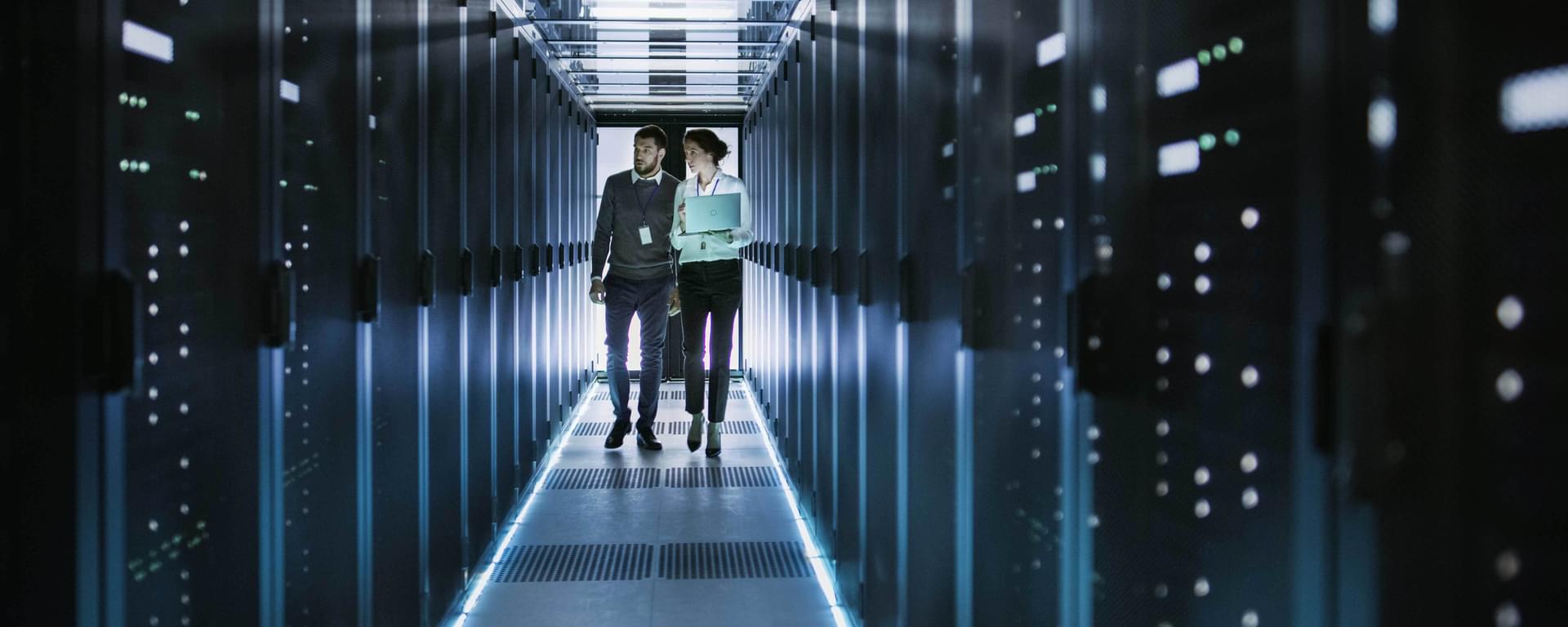 People walking through rack servers in data centre