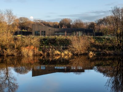 Bothy & Tùr - external view of building from across the lake with reflection of building in water Bothy & Tùr - external view of building from across the lake with reflection of building in water