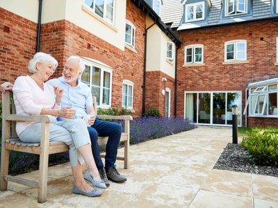 Retired couple sitting on a bench in an assisted living facility Retired couple sitting on a bench in an assisted living facility