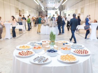 Round table with white tablecloth with plates of food at conference Round table with white tablecloth with plates of food at conference