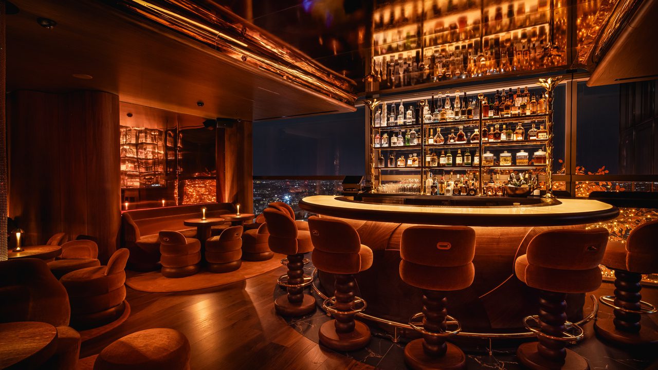 Sushi Samba bar area with high stools and shelves of bottles behind the bar Sushi Samba bar area with high stools and shelves of bottles behind the bar
