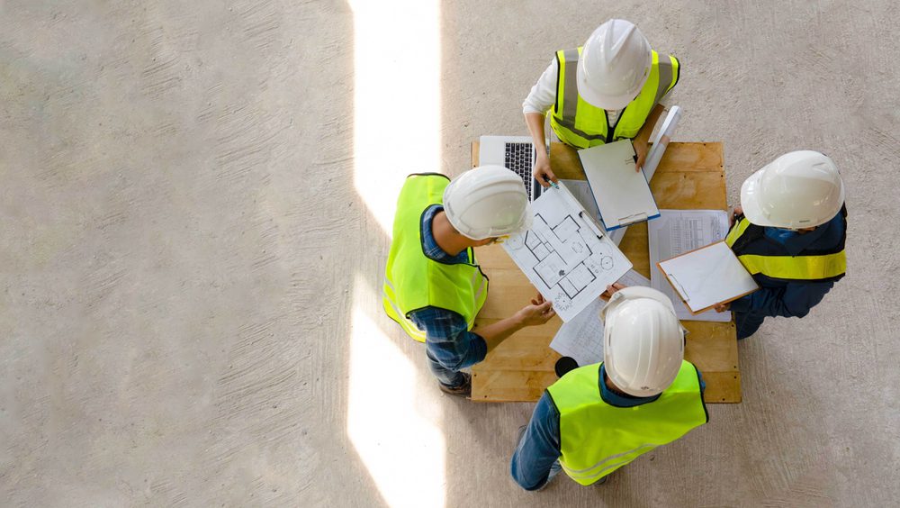 Meeting with team while inspecting construction progress
