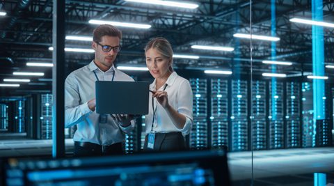 Man and women with laptop in data centre