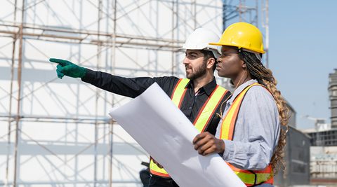 Man and women construction worker looking at drawing